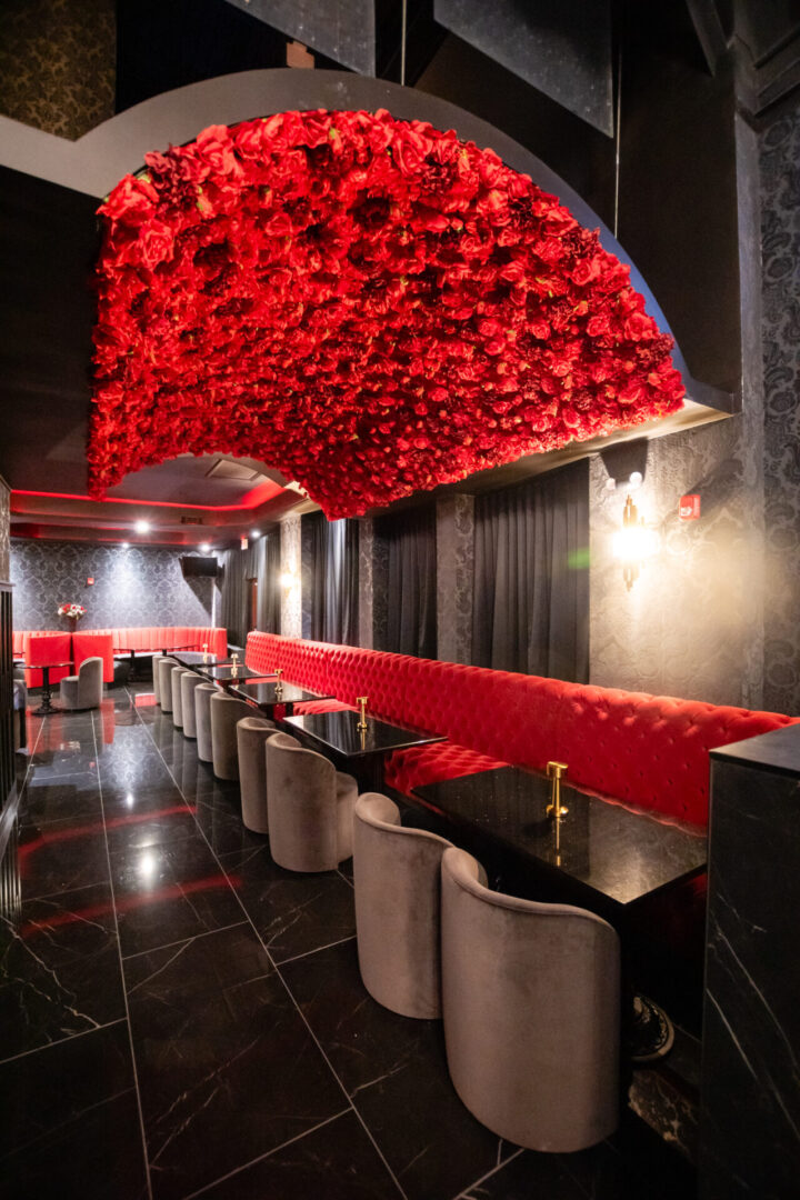 A luxury lounge with red roses hanging from the ceiling.