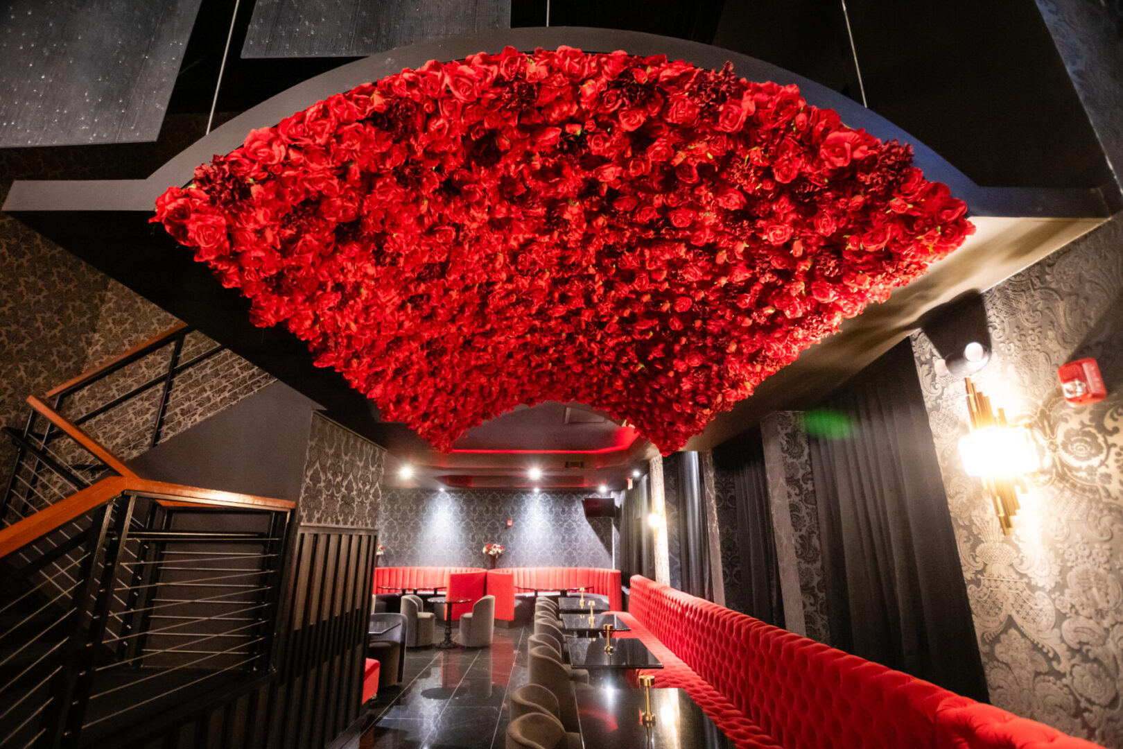 A luxury lounge with red flowers hanging from the ceiling.