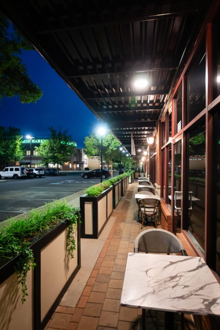 An outdoor patio with luxury lounge tables and chairs at night.