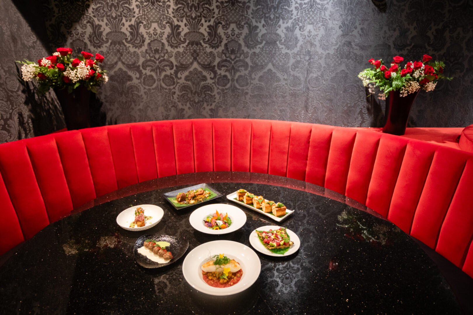 A table in a luxury lounge with plates of food on it.