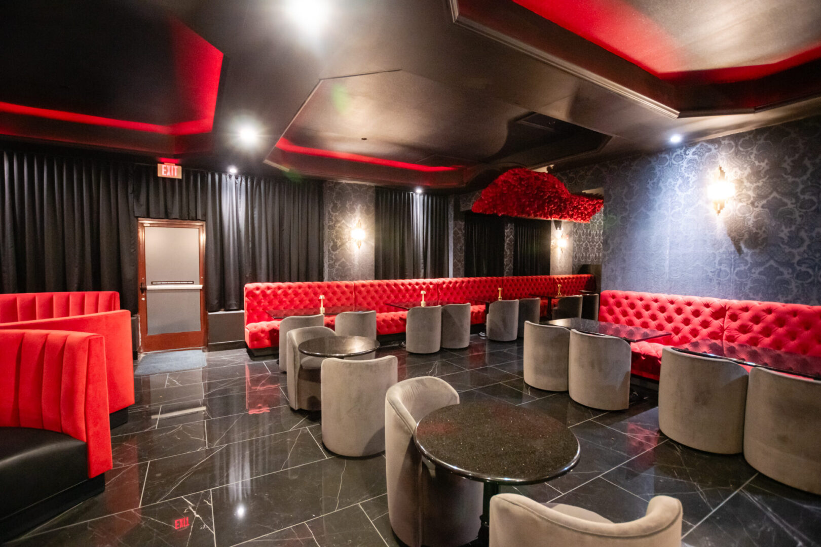 A red and black luxury lounge with tables and chairs.