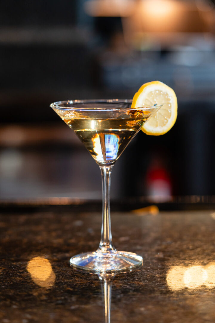 A luxury lounge martini glass with a lemon wedge in it.