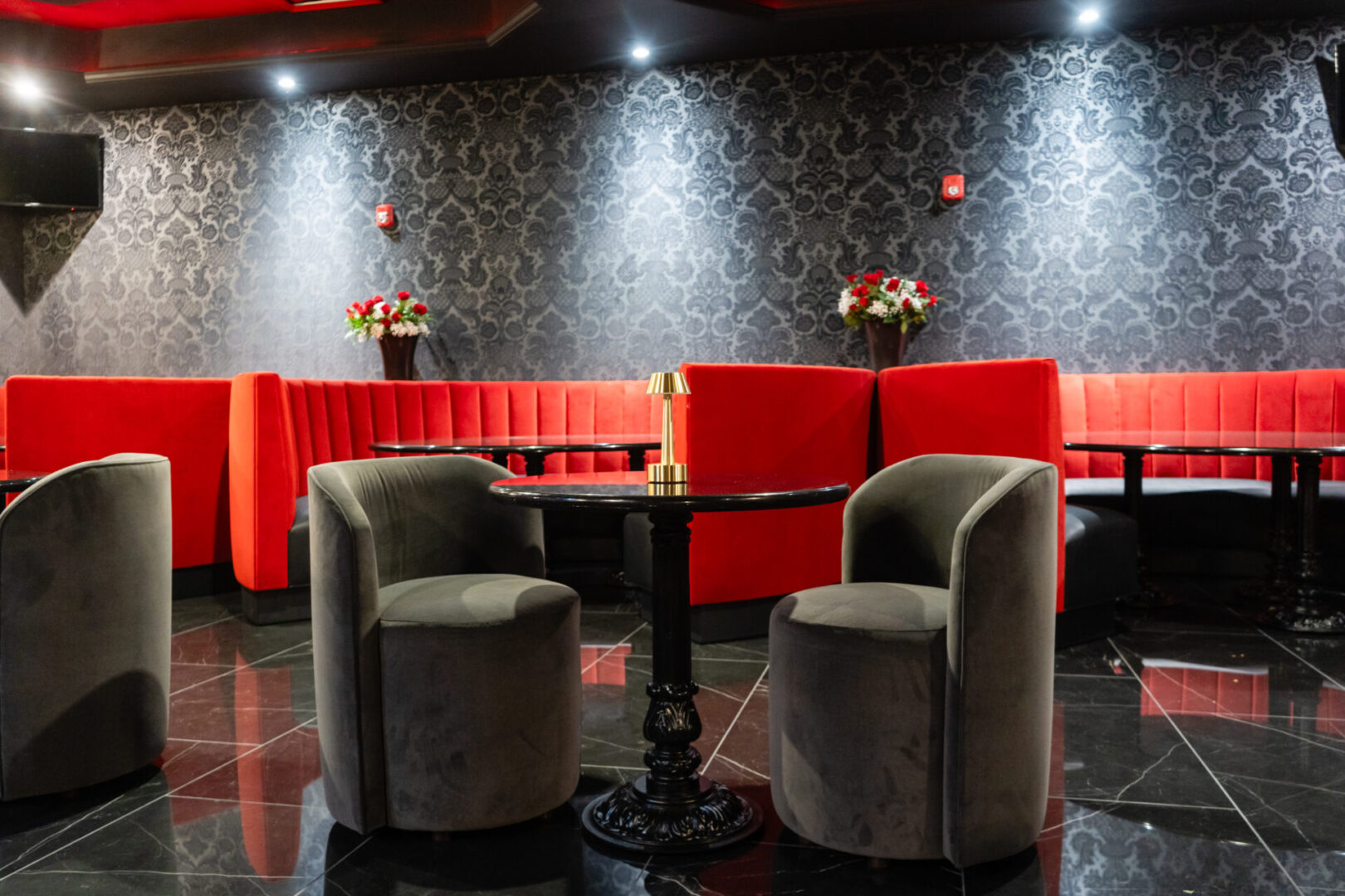 A black and red luxury lounge with tables and chairs.
