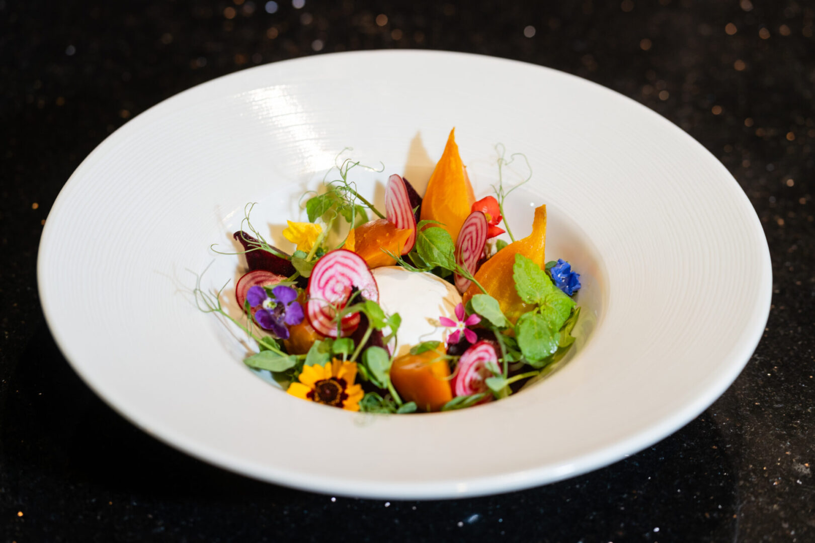 A white bowl with vegetables in it, placed in a luxury lounge.