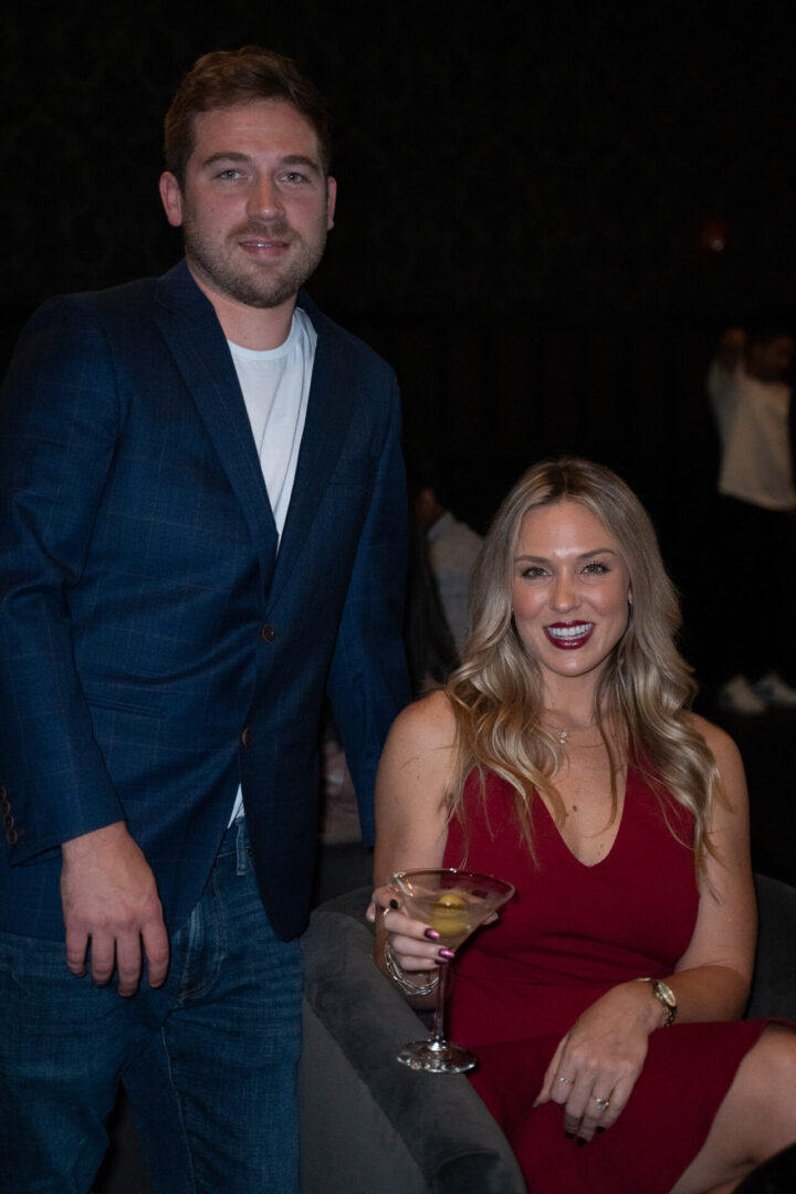 A man and woman posing for a photo in a luxury lounge at an event.