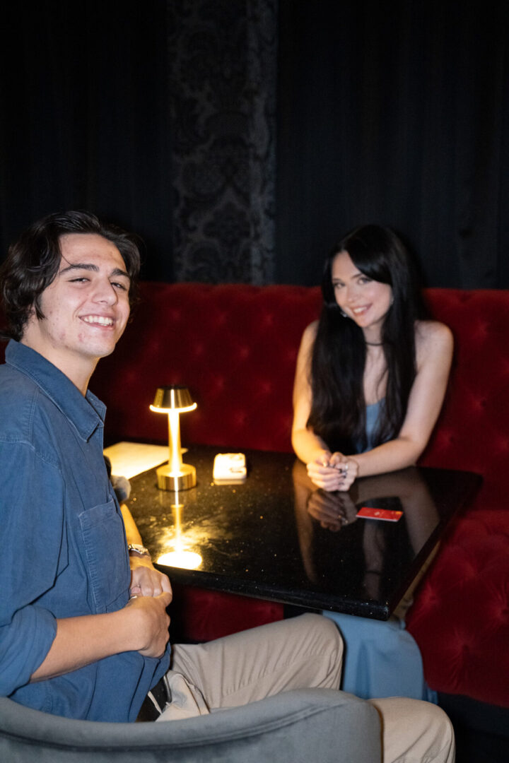 Two people sitting at a table in a luxury lounge.